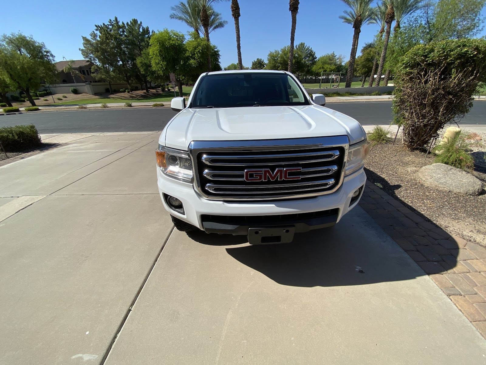 White GMC Canyon washed and shining in a Chandler driveway