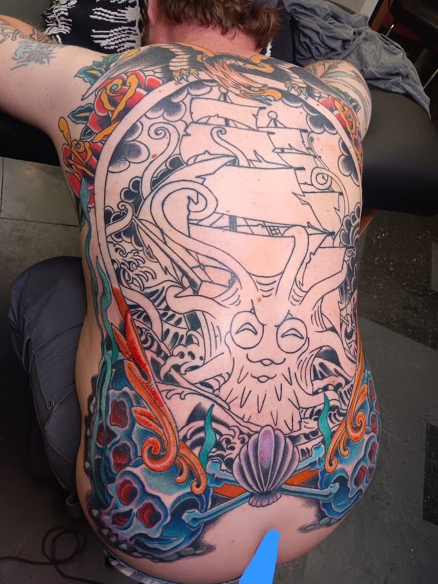 Full back piece in progress with ship, waves and color sections