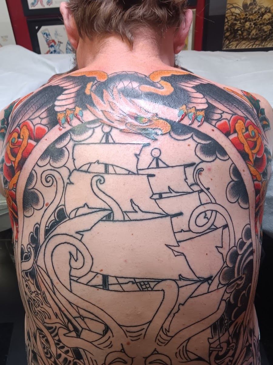 Back piece linework of a sailing ship framed by an eagle and roses