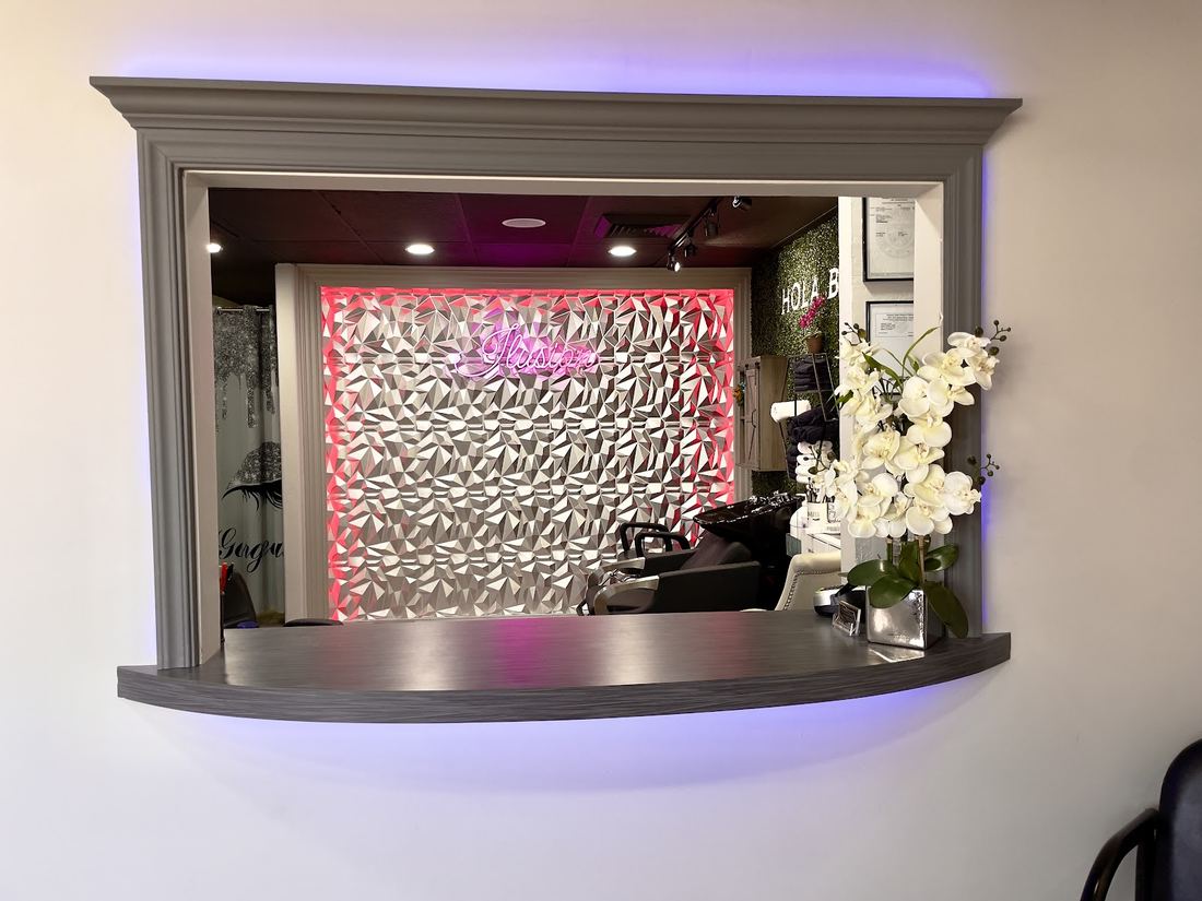 Window into the shampoo room with a pink lit textured wall