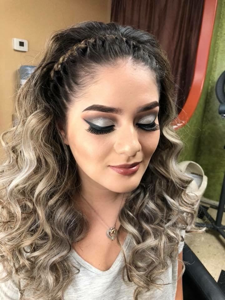 Client with a braided crown, soft curls and full glam makeup