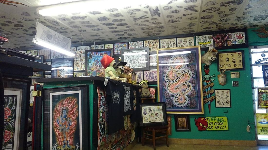 Wide view of the shop with a framed dragon painting and flash covering every wall