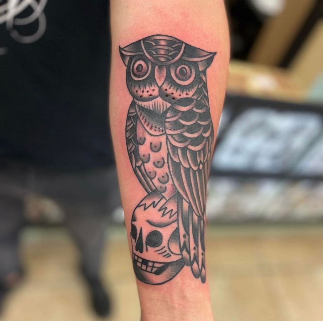 Blackwork owl perched on a skull tattoo