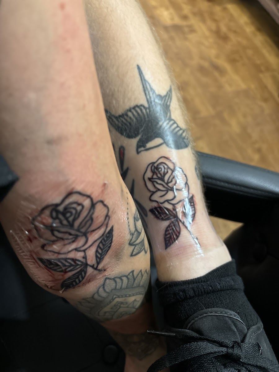 Black and grey roses with a swallow on an arm