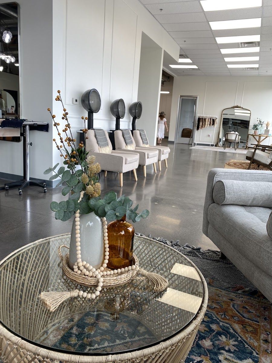 Glass side table with a eucalyptus vase and wood bead garland in the salon