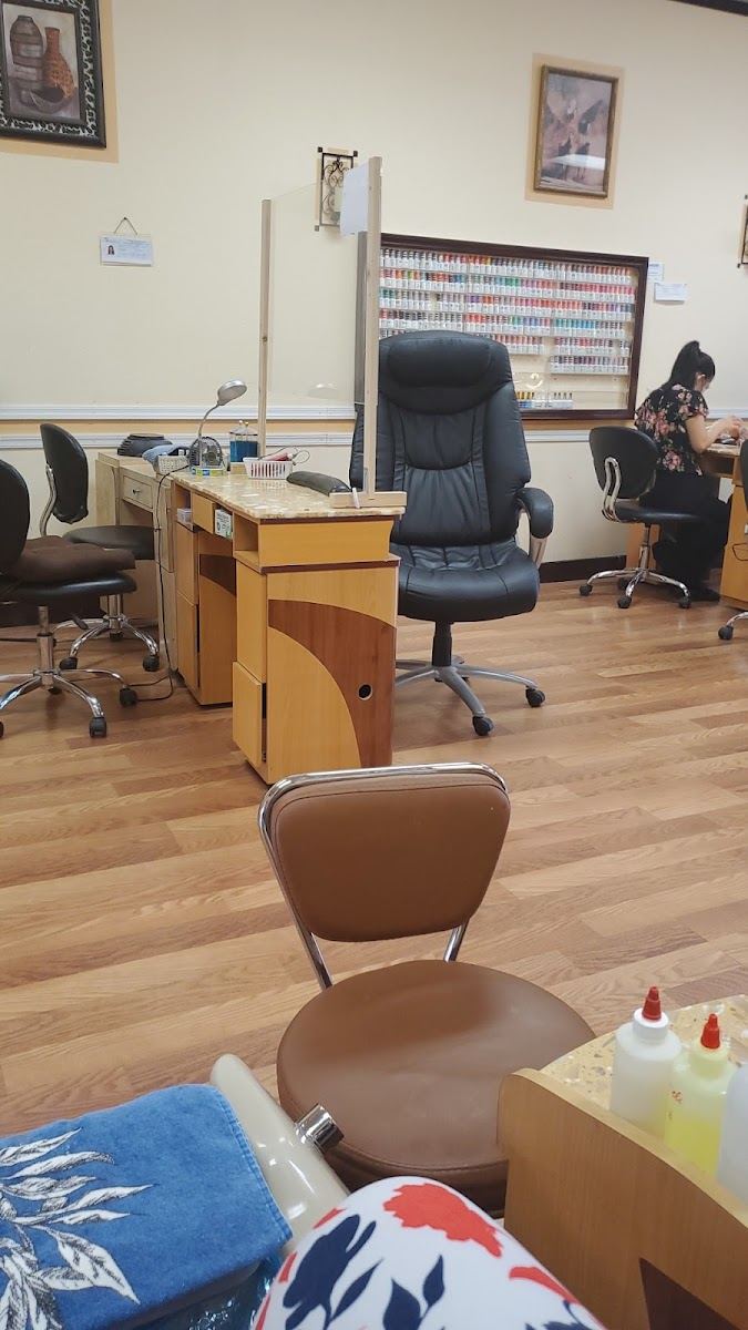 Inside Jolie Nail Spa: manicure stations, a pedicure chair and a wall of polish