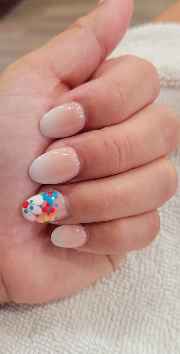 Short nude nails with a colorful flower accent nail
