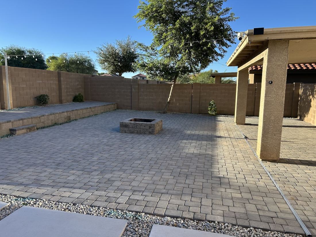 Wide paver patio with a square fire pit and a raised paver step