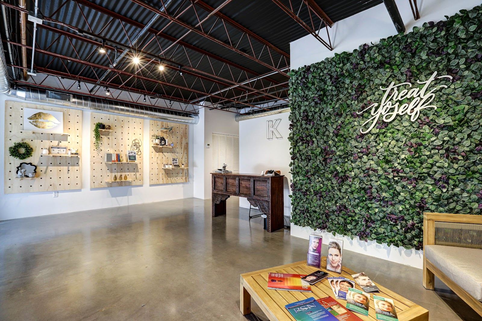 The K Wellness Collective studio with its living plant wall and pegboard shelves