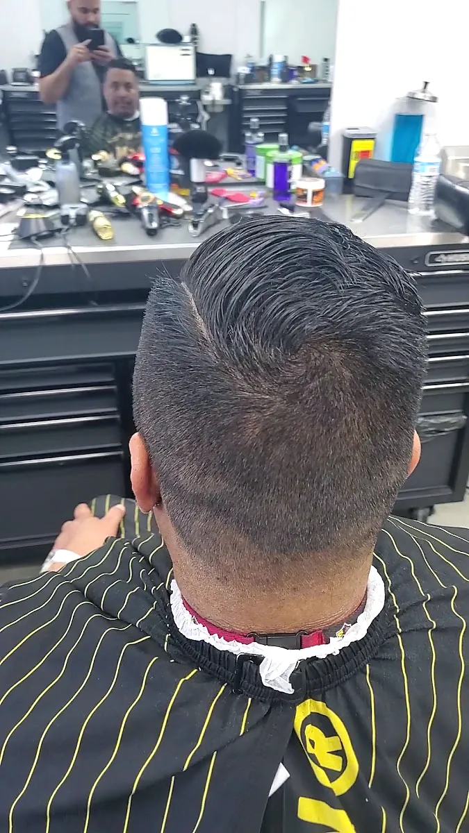 Back of a fresh cut above a black cape with gold pinstripes
