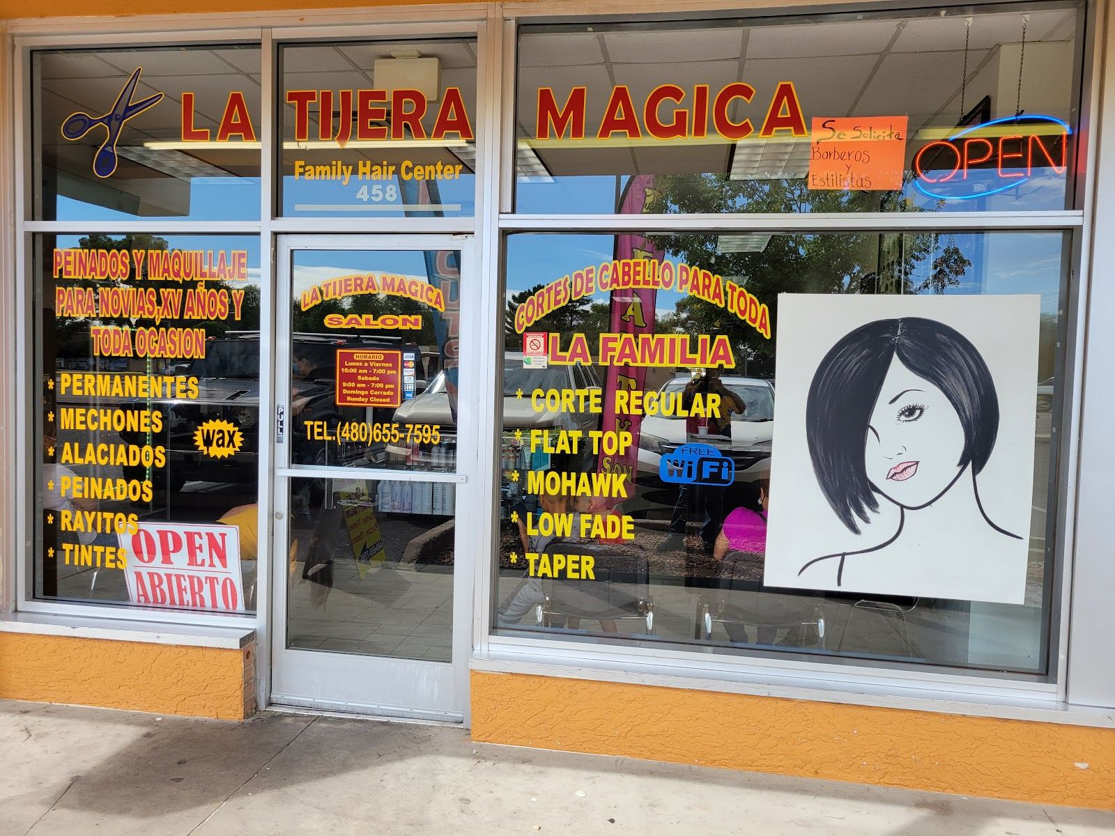 La Tijera Magica storefront with its name in orange letters and service lists in the windows