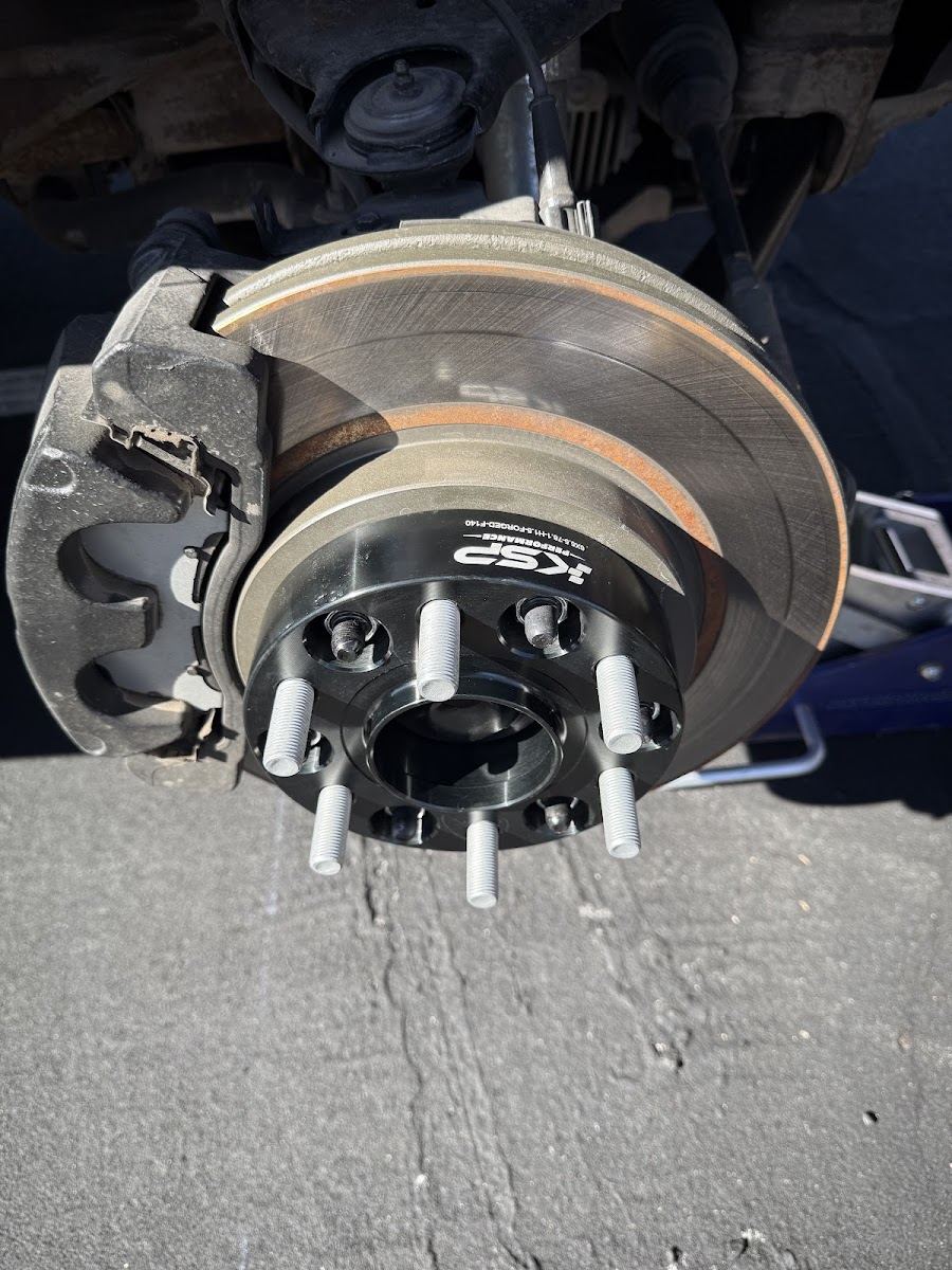 Brake rotor and caliper on a lifted truck with the wheel removed