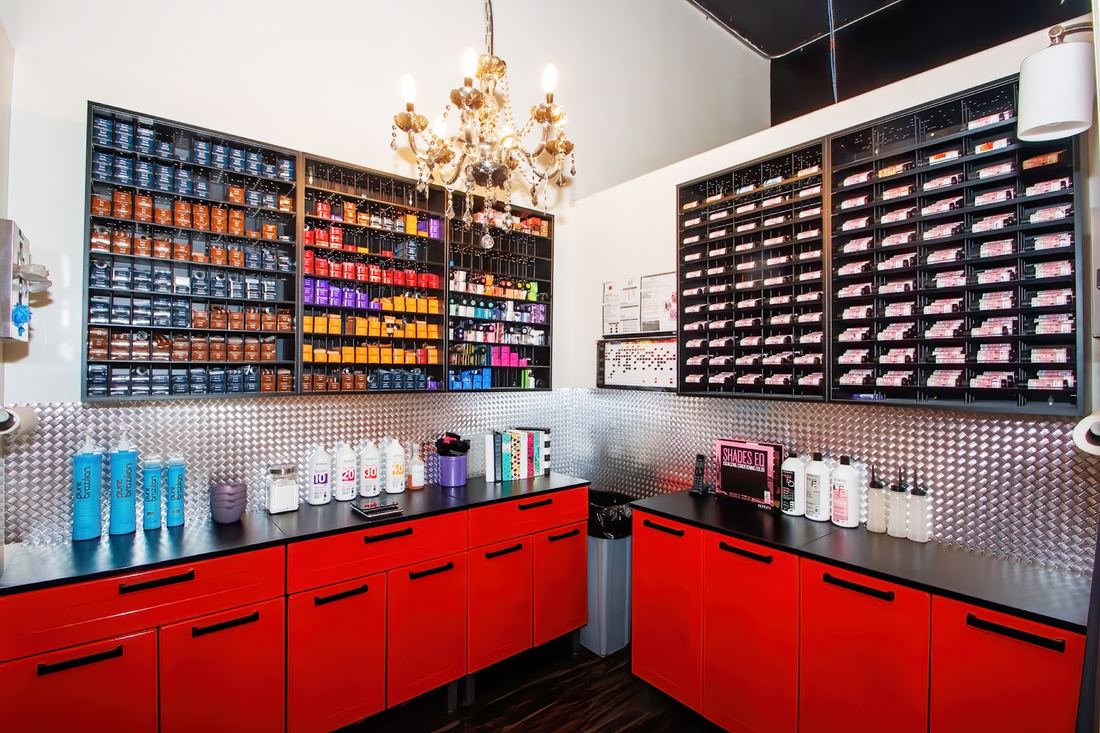 The salon color bar with rows of color tubes above red cabinets