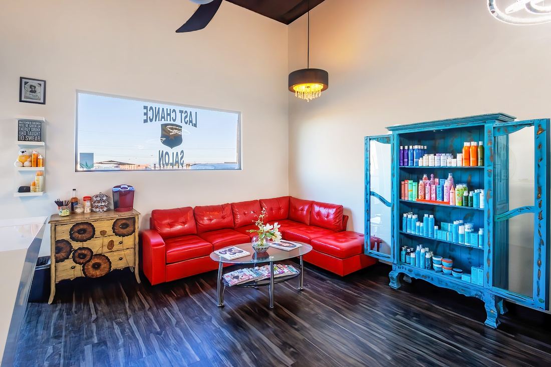 The waiting lounge with a red leather sofa and a teal product cabinet