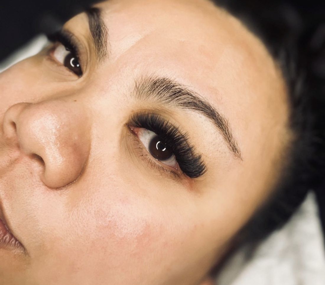 Close up of dark, wispy lashes on a client looking up