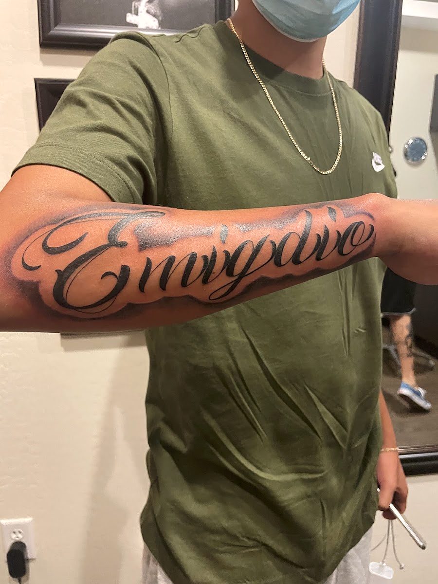 Shaded script lettering across the length of a forearm