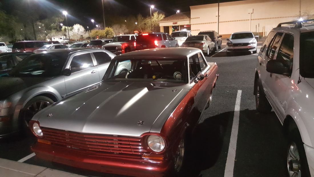 Classic two tone sedan in red and silver parked under lights at night