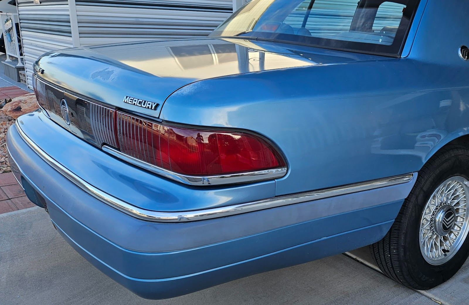 Rear quarter of a light blue Mercury sedan with a glossy paint finish