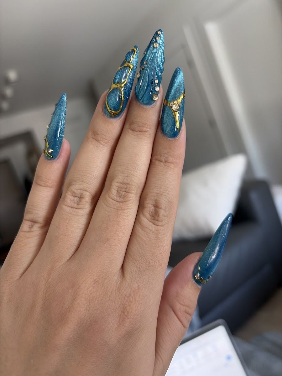 Long teal almond nails with gold swirl art