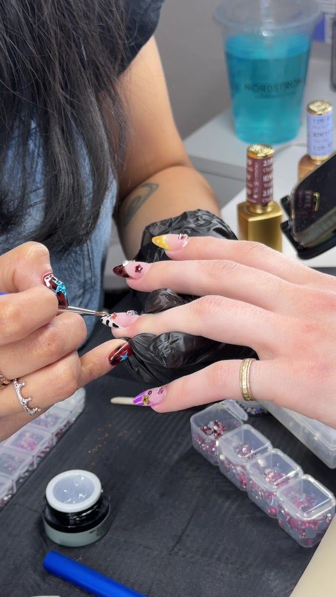 Nail artist hand-painting detailed art on a client's nails