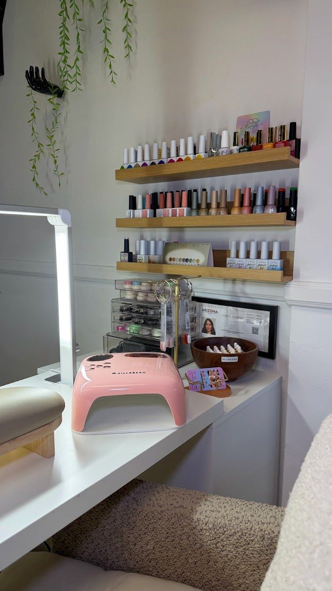 Nail station with a pink LED lamp and shelves of gel polish