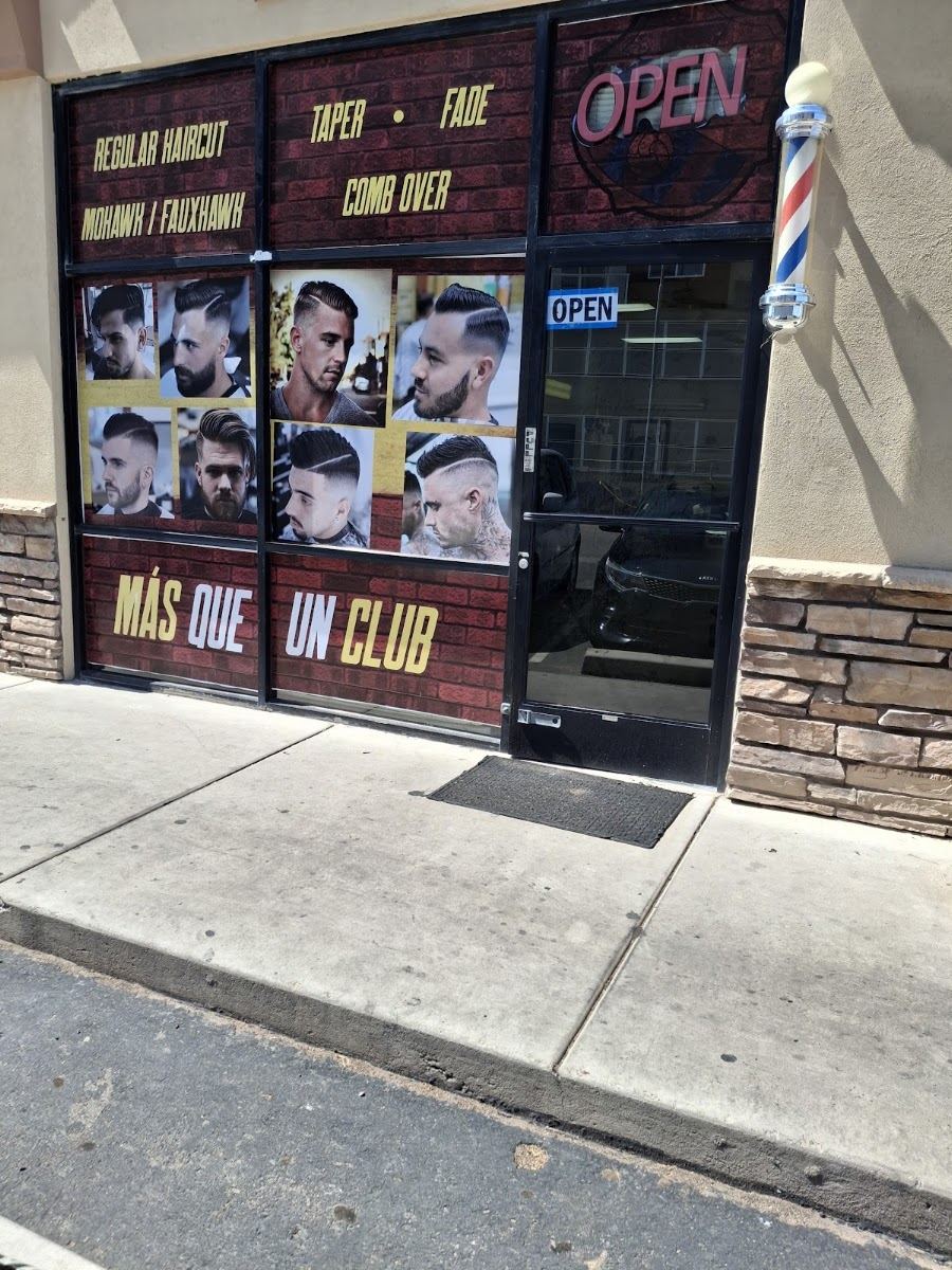 Master Cut Barber storefront with a red brick style window wrap, haircut style photos, a lit OPEN sign and a spinning barber pole