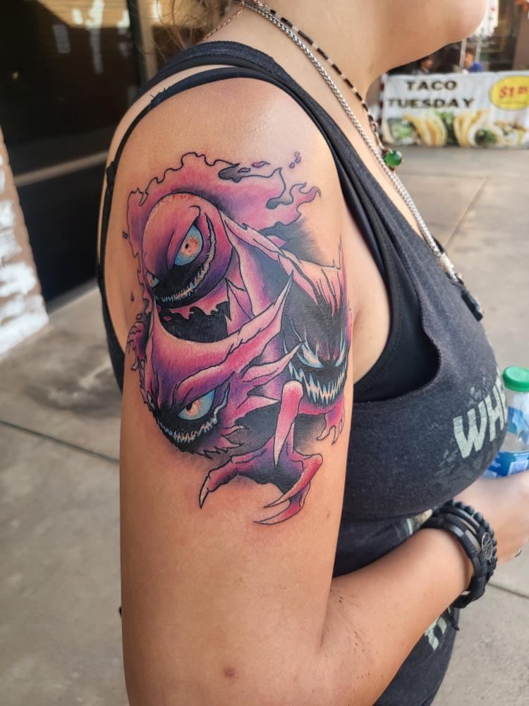 Pink and purple illustrative tattoo on a shoulder