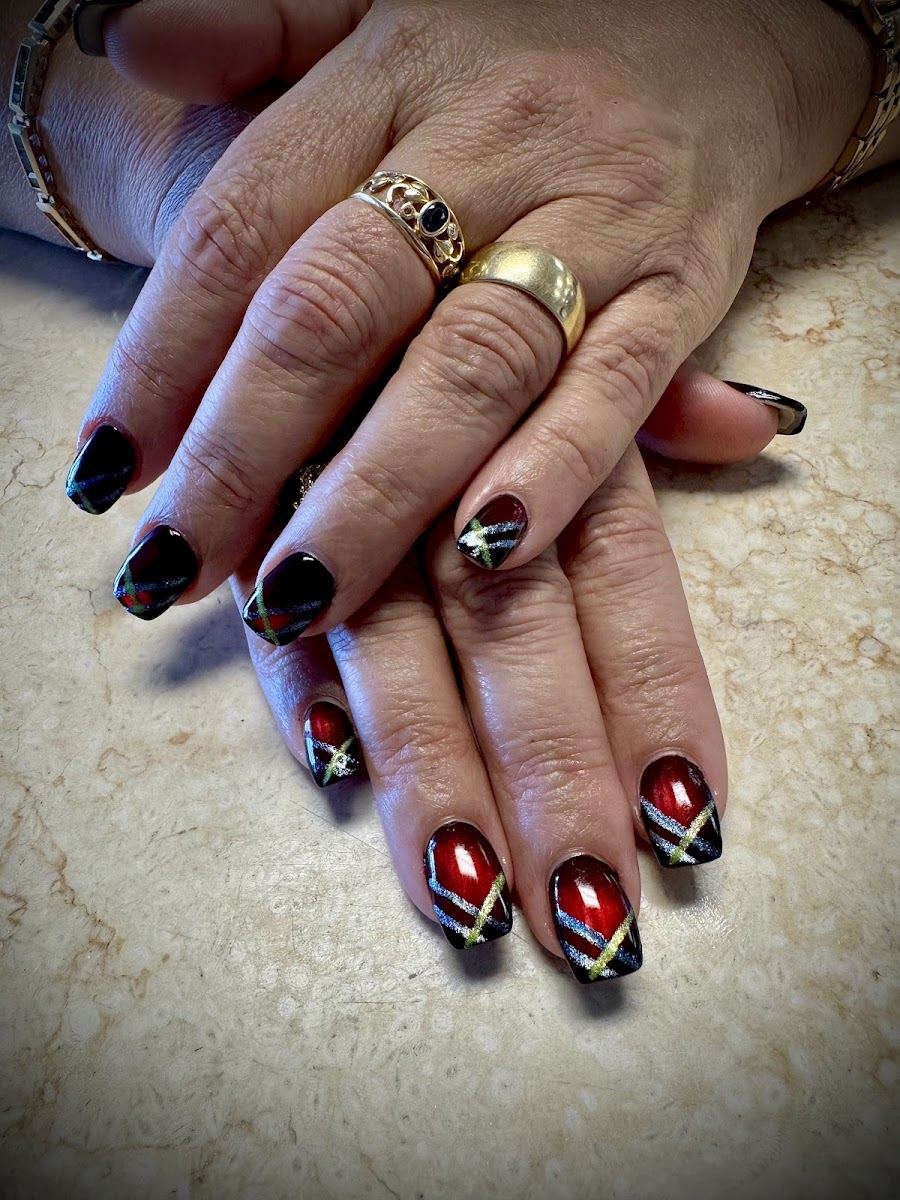 Short nails in black and deep red with gold and white star accents