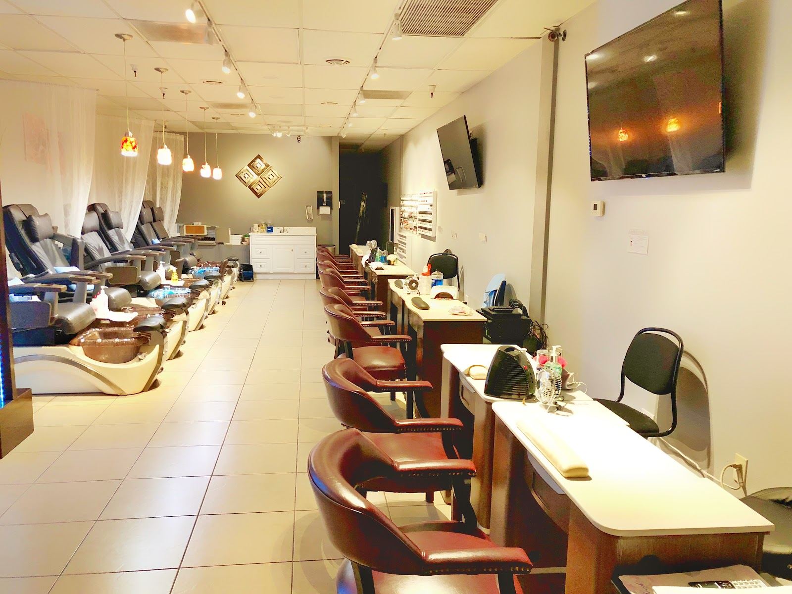 Inside Nail Pro Shop: a long bright room with manicure tables on one side and pedicure chairs on the other