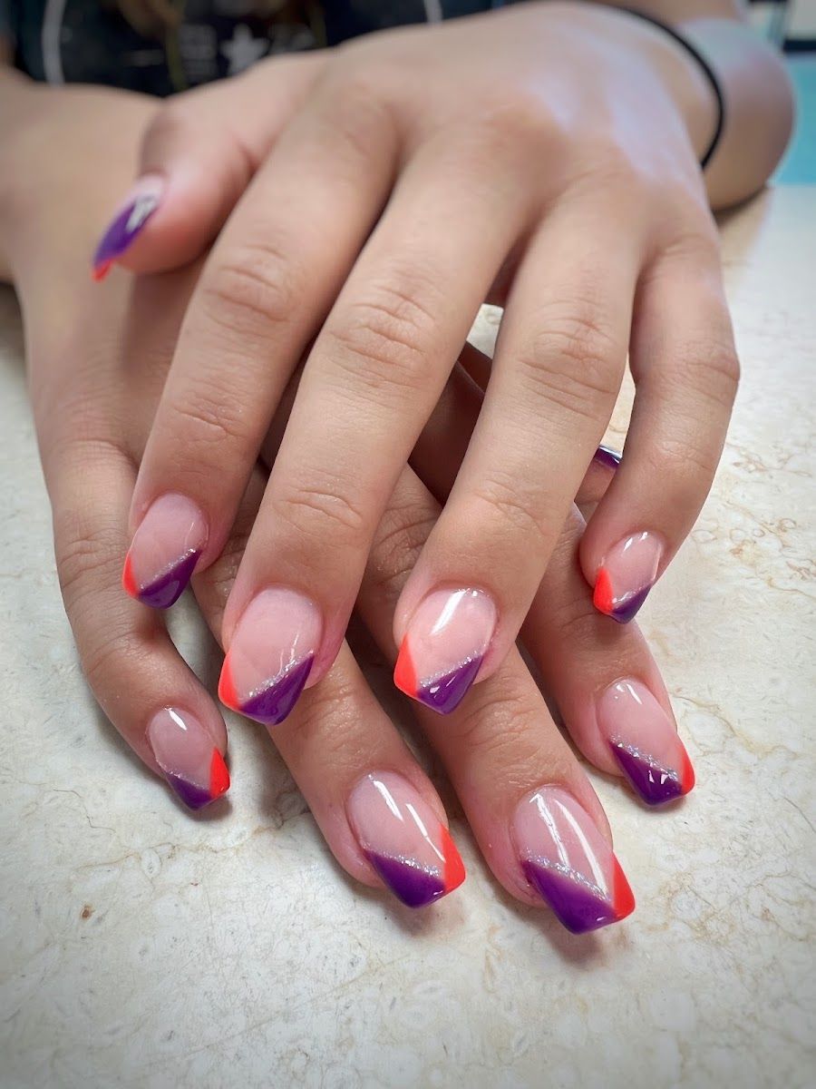 Nude nails with angled orange and purple French tips