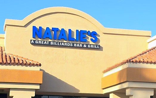 The NATALIE'S sign in blue letters on a tan stucco facade with a red tile roof: A Great Billiards Bar and Grill
