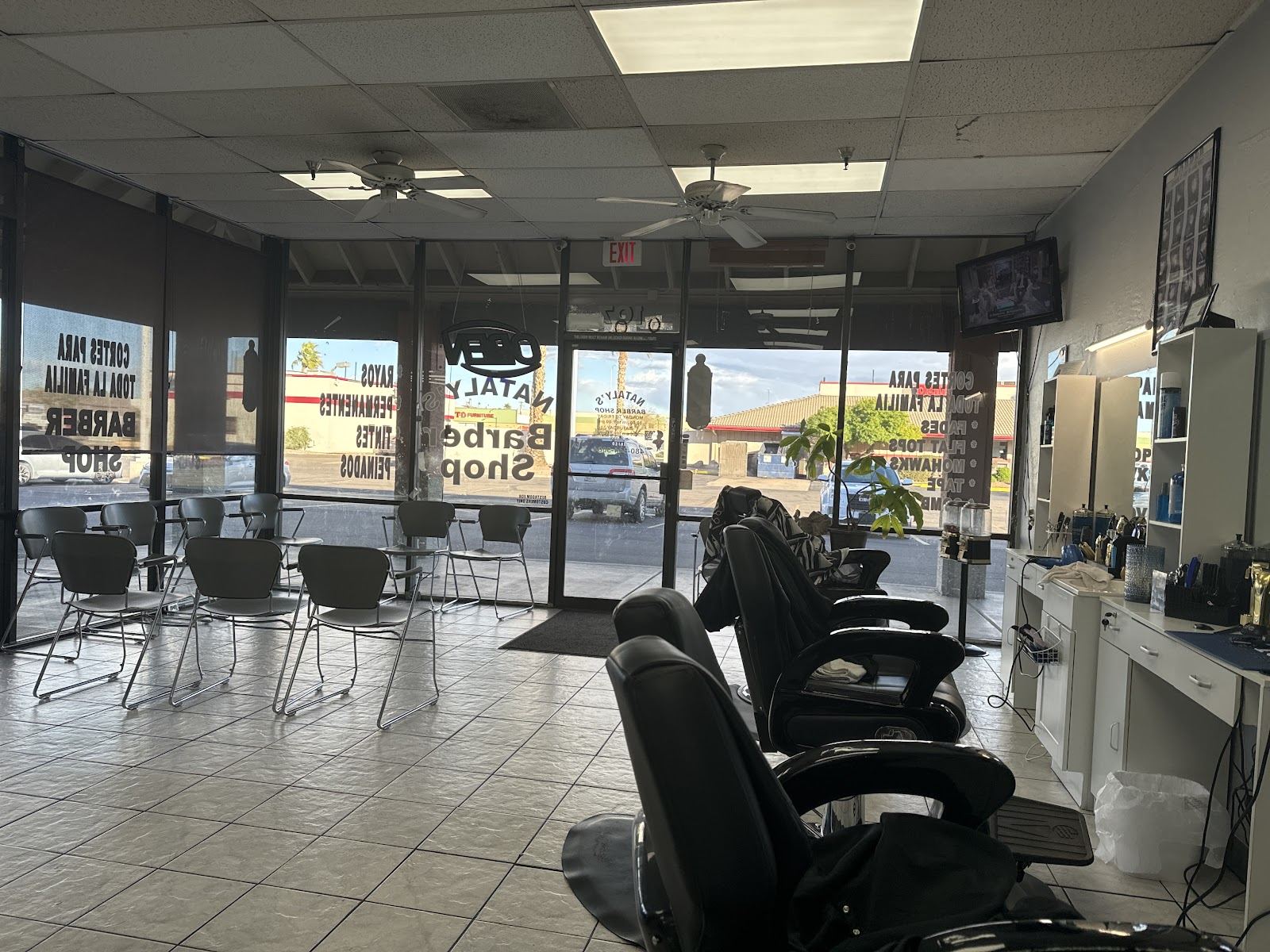 Inside Nataly's Barber Shop: a row of barber chairs and stations under bright windows