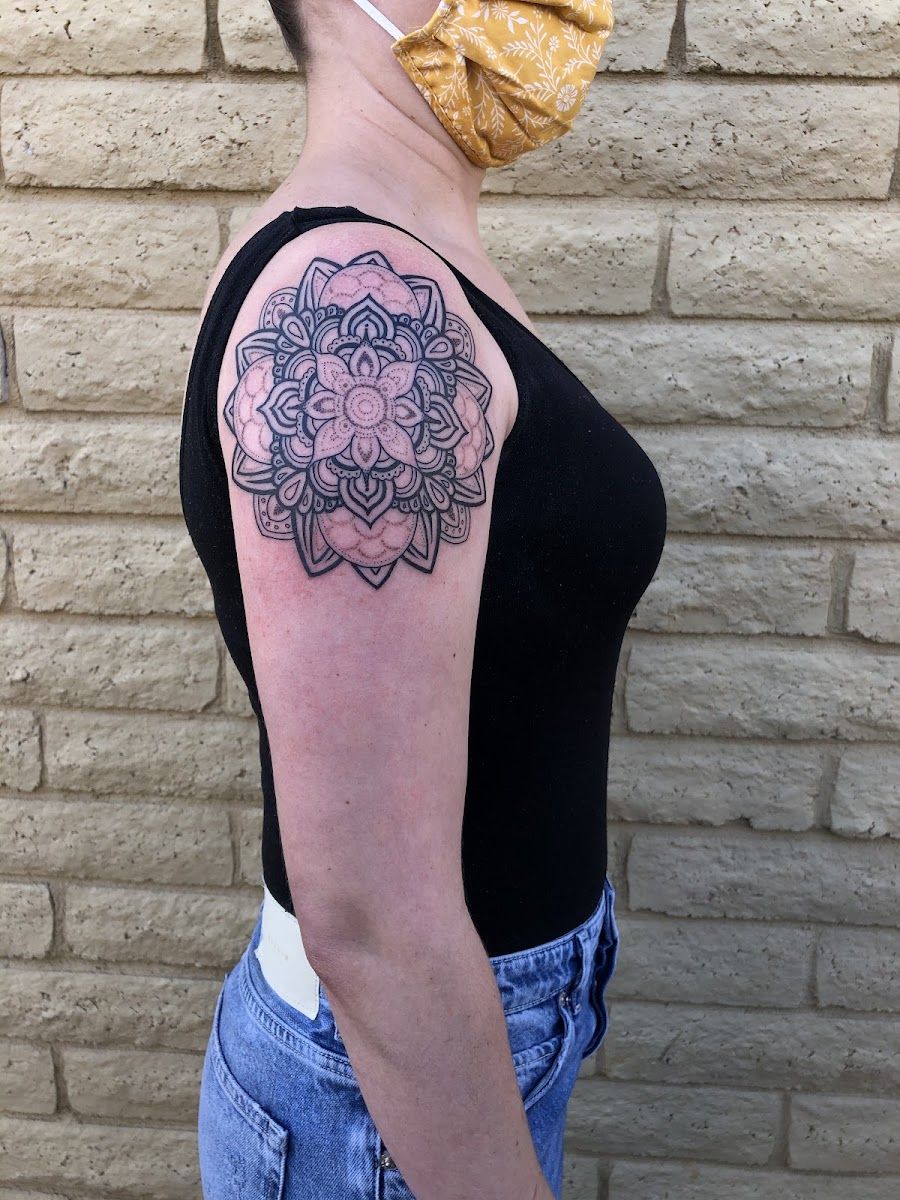 Black and grey mandala tattoo on an upper arm