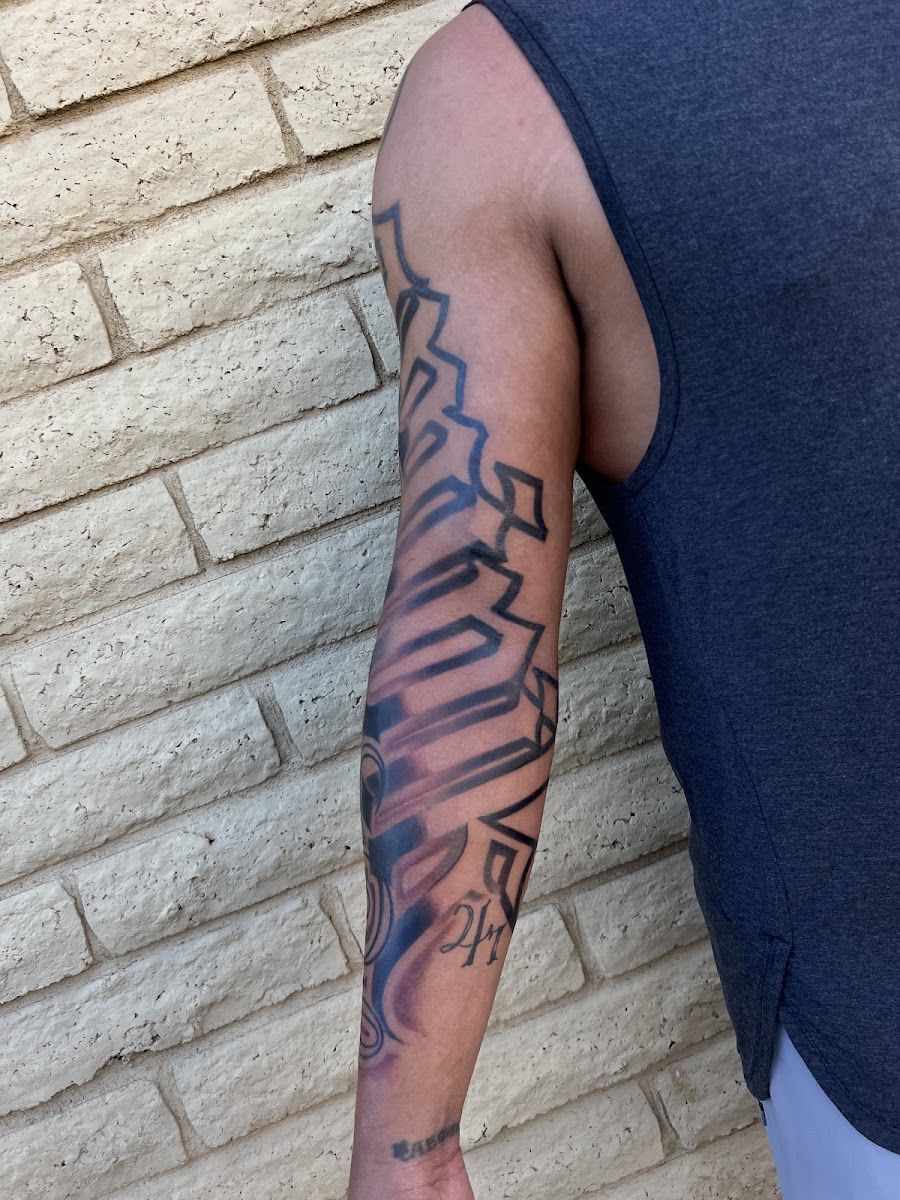 Black and grey sleeve with bold geometric shapes on an arm