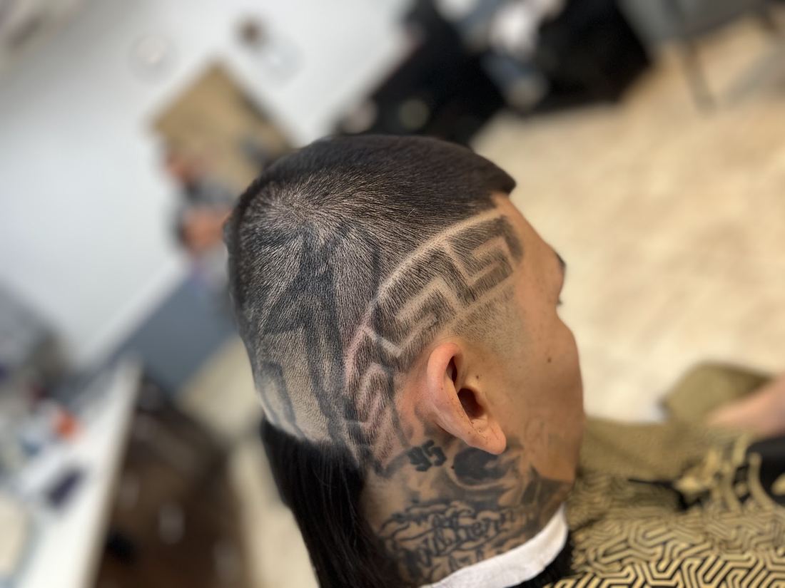 Side view of a freestyle hair design cut into a client's fade