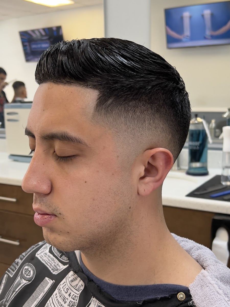 Client in profile with a clean low fade and slicked top