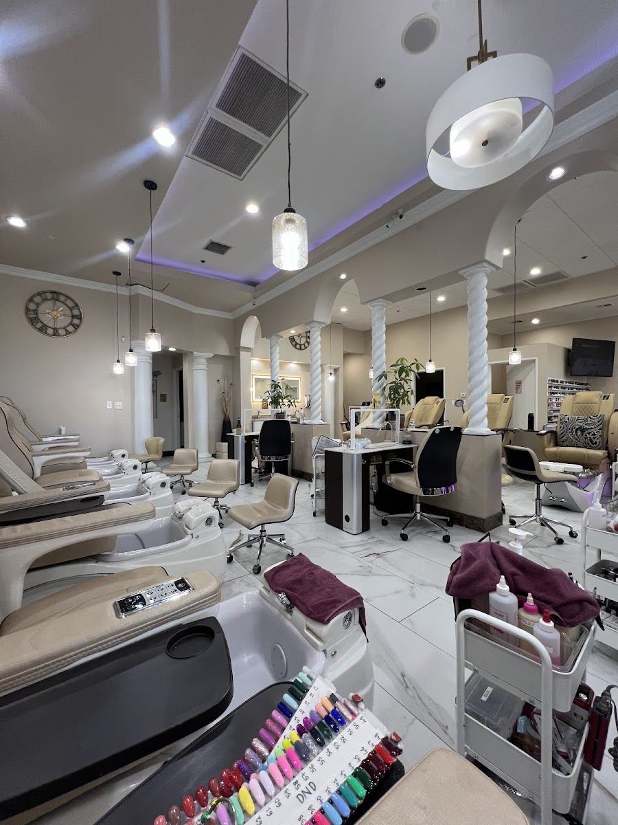 Inside Ocean Spa and Nails: rows of cream pedicure chairs with blue basins under warm pendant lights