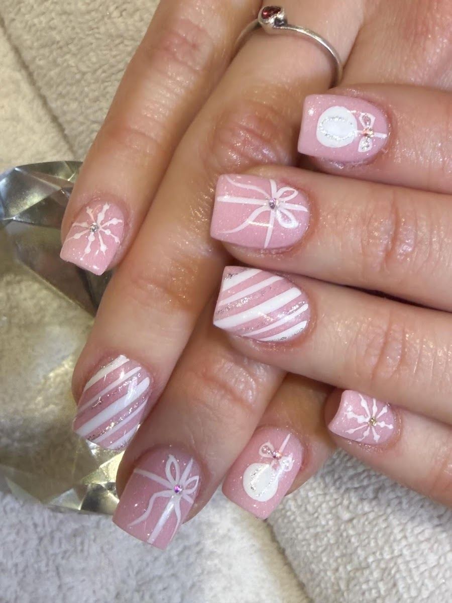 Soft pink nails with hand-painted bows and snowmen