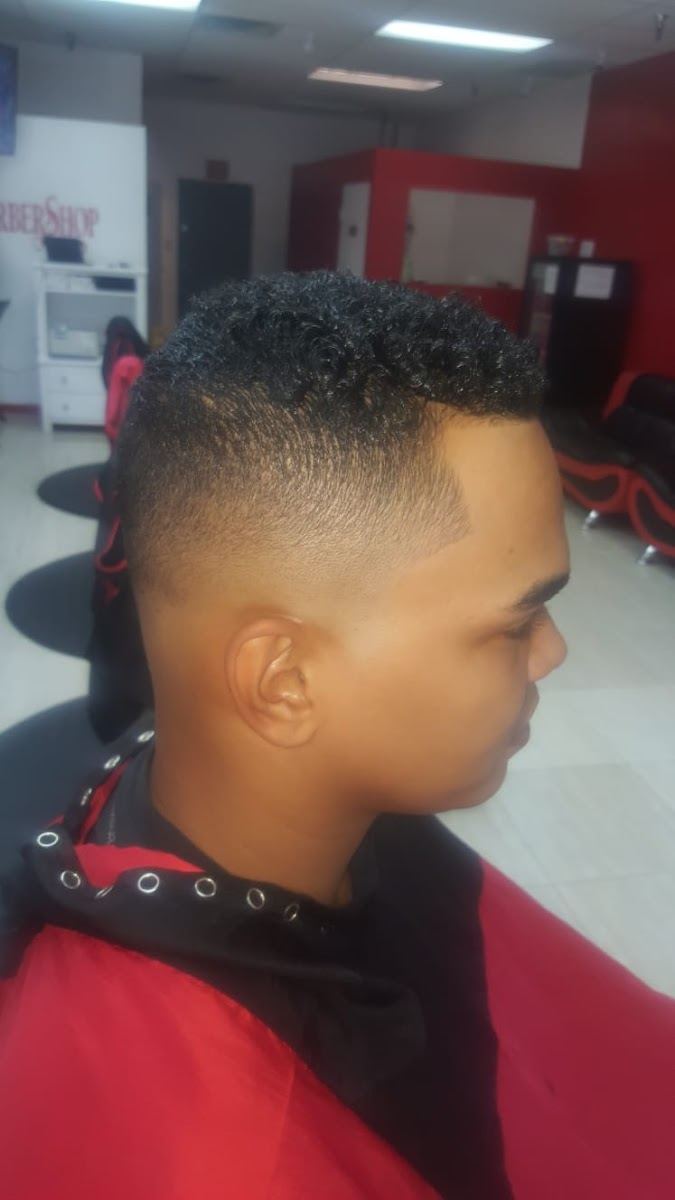 Curly top with a clean taper fade, side profile