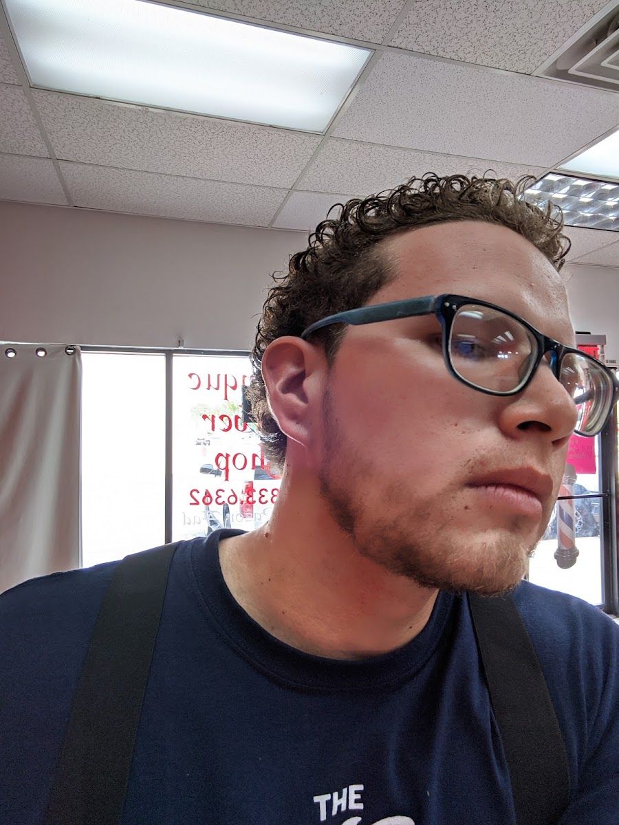 Client with curly hair and a sharp beard line-up