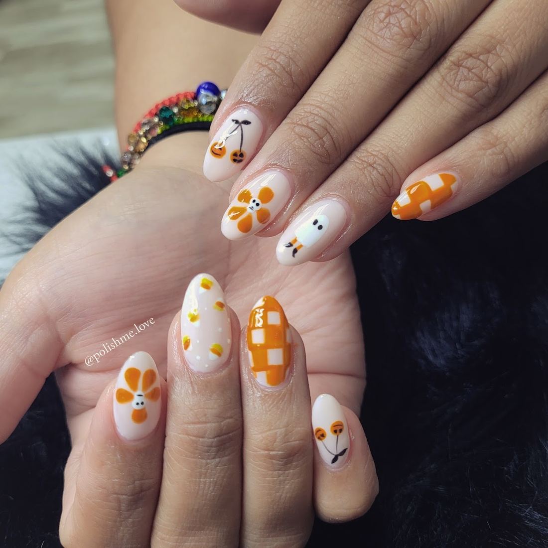 Short nails with orange flowers, checkerboard and cherry art