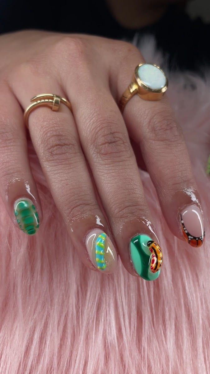 Green and pink nail art with a gold ring