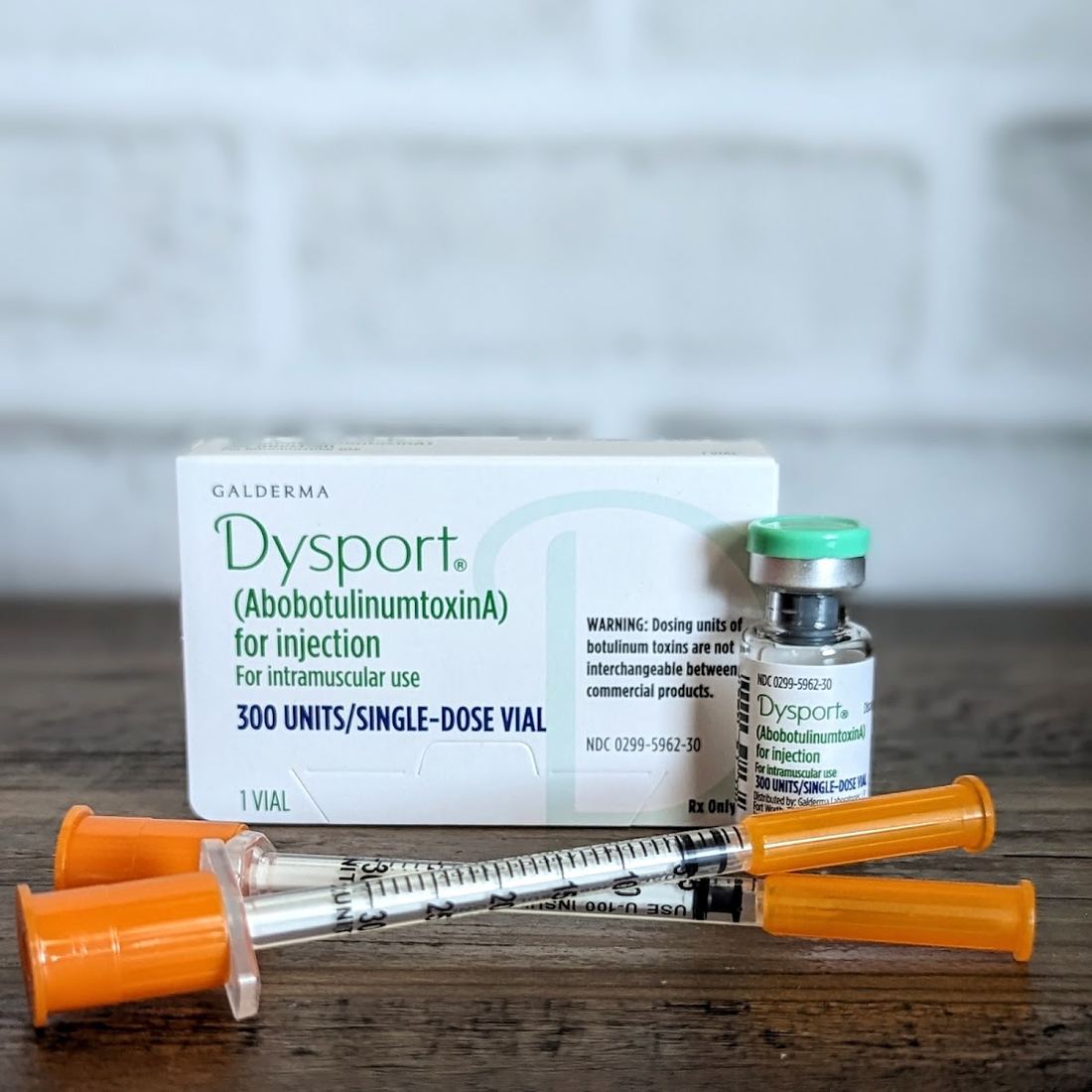 Dysport box, vial and syringes on a wooden table at the studio
