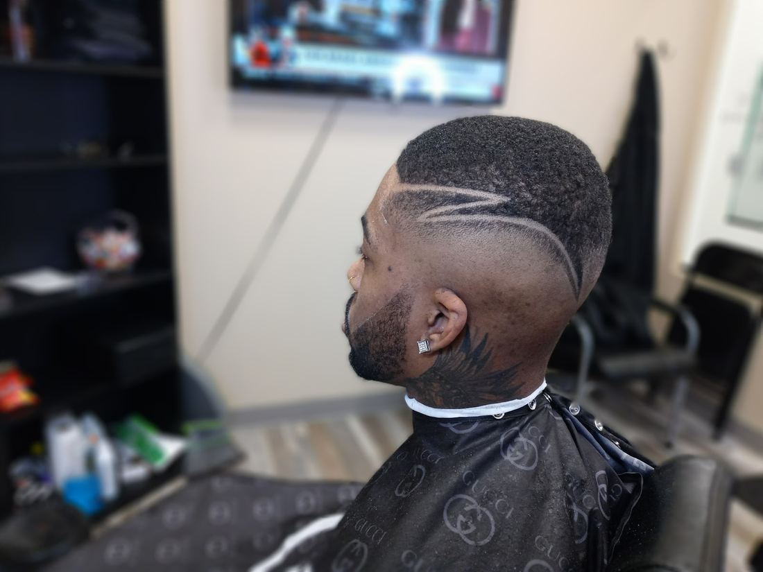 Side profile of a fade with two razor design lines and a sharp beard line