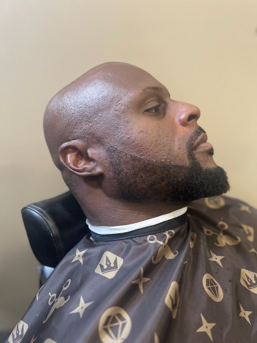 Client reclined in the chair showing a sharp, freshly shaped full beard