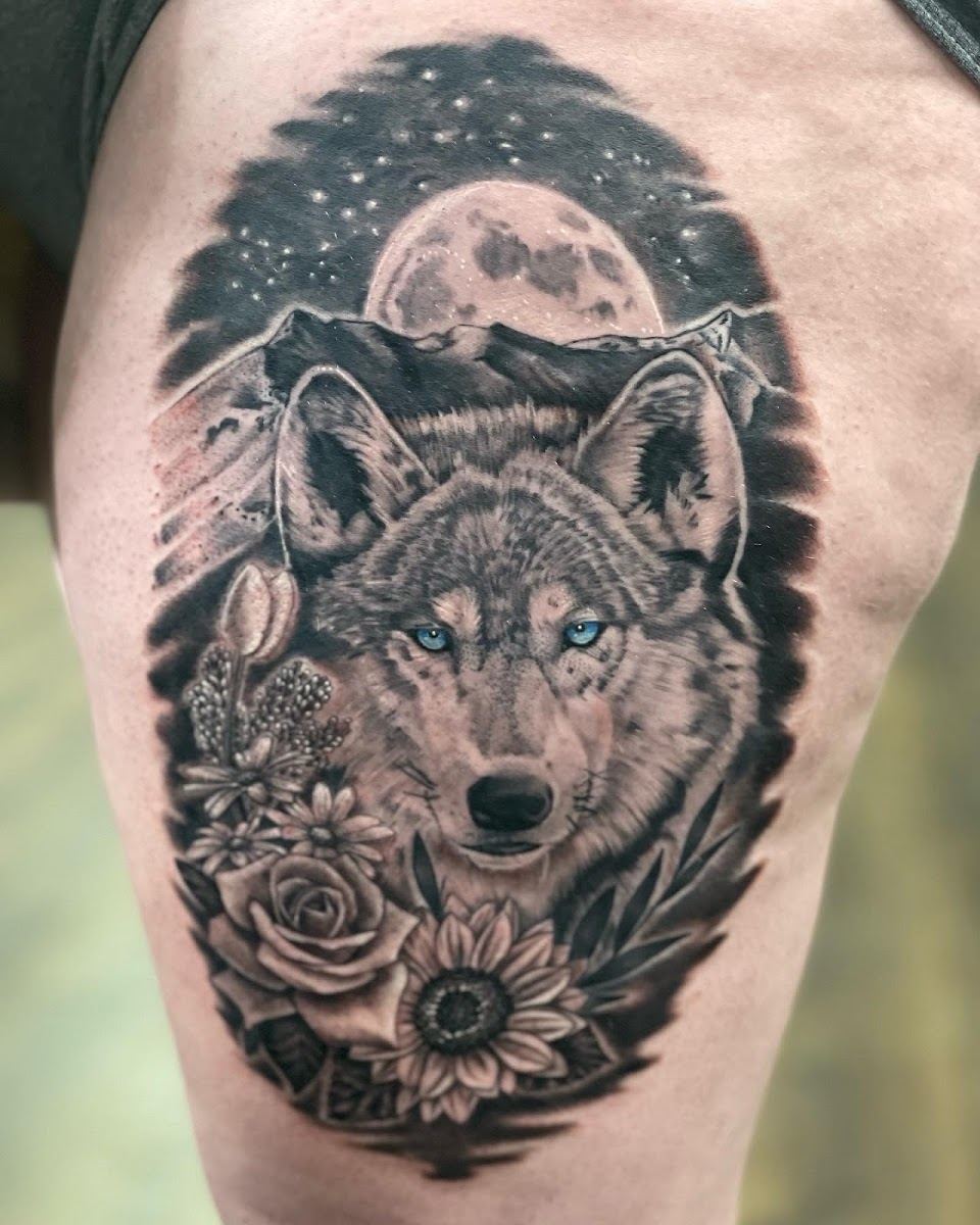 Black and grey wolf tattoo with moon, mountains, roses and sunflower