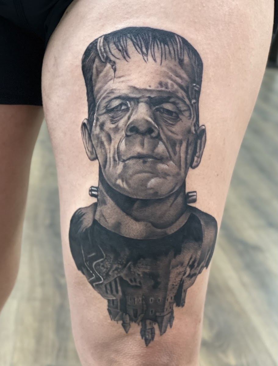 Black and grey Frankenstein portrait tattoo on a thigh