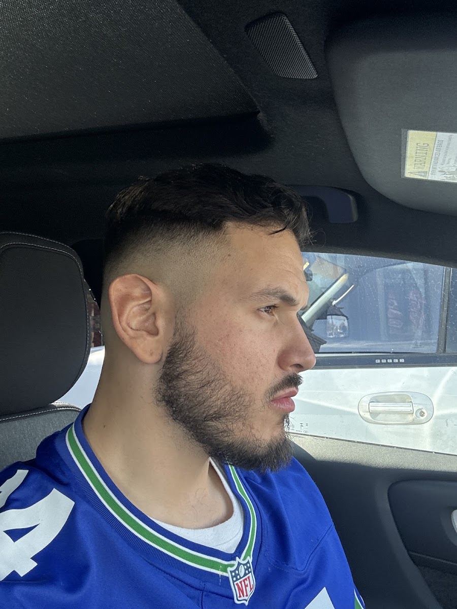 Client with a skin fade, hard part and trimmed beard