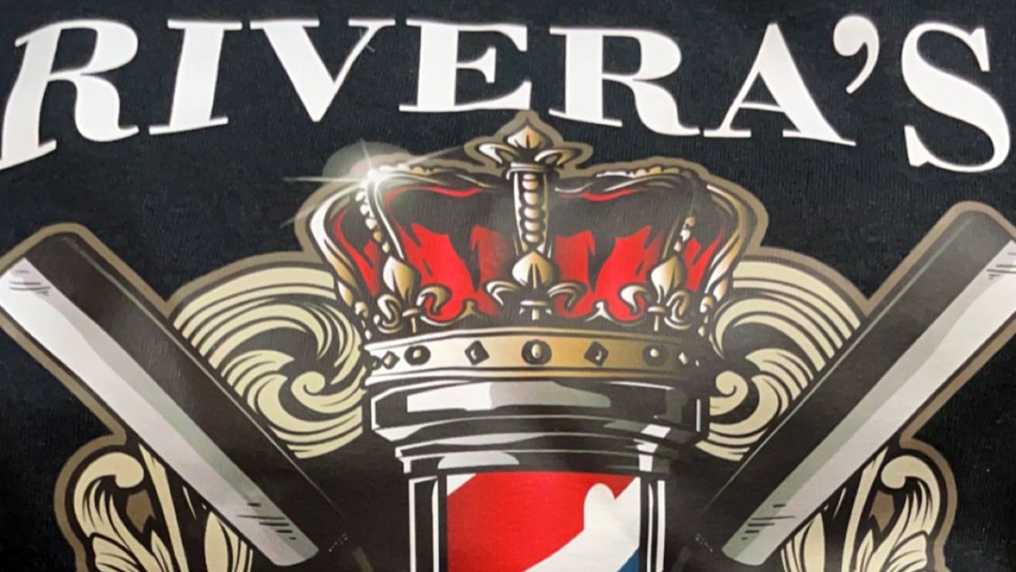 Close-up of the Rivera's crest with a crown, barber pole and crossed razors