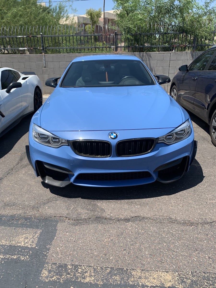 Blue BMW M4 front end in a parking lot